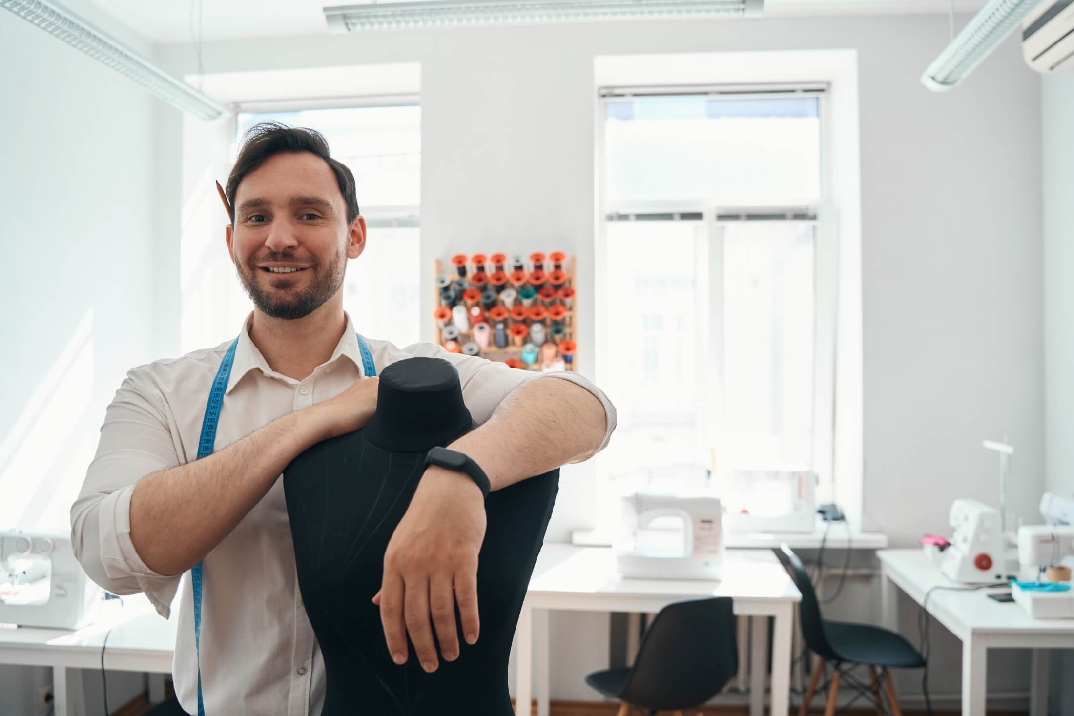 Krawiec w swojej pracowni oparty o manekina